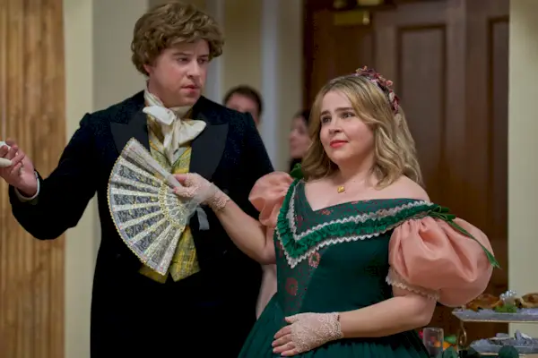 Ein Mann und eine Frau in historischen Kostümen; Sie hält einen dekorativen Fächer.