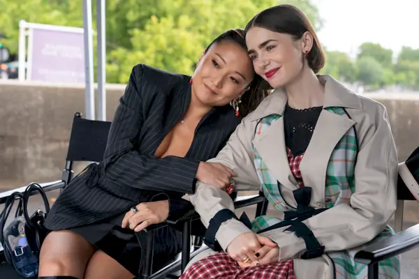 Deux femmes assises et s'appuyant l'une sur l'autre en souriant