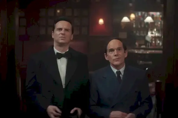 Deux hommes aux cheveux dégarnis, en costume et cravate, regardent vers le haut.