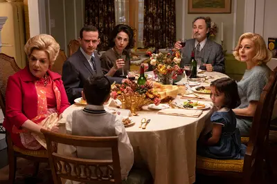The Maisel family seated around the dinner table in 