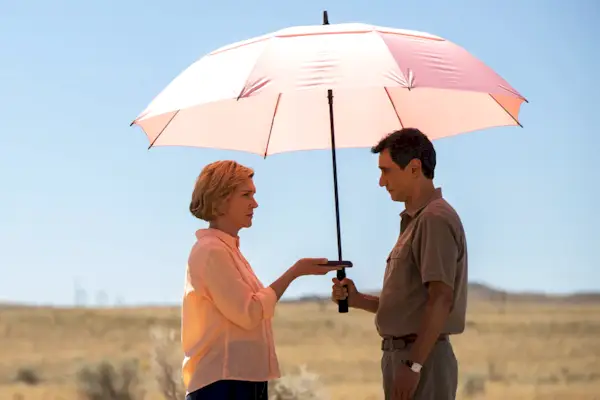 Un homme et une femme debout sous un parapluie rose au milieu du désert du Nouveau-Mexique