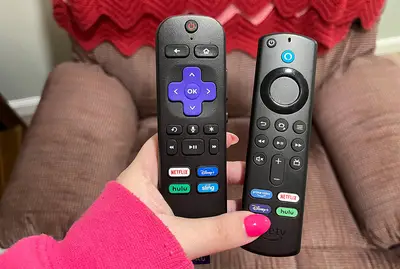 roku and fire tv remotes in hand