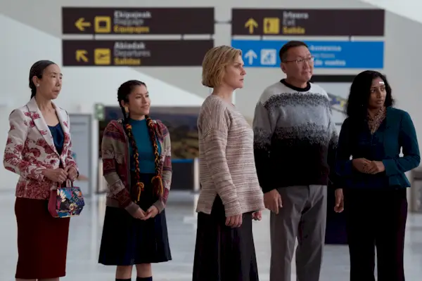 Cuatro mujeres y un hombre de pie en un aeropuerto