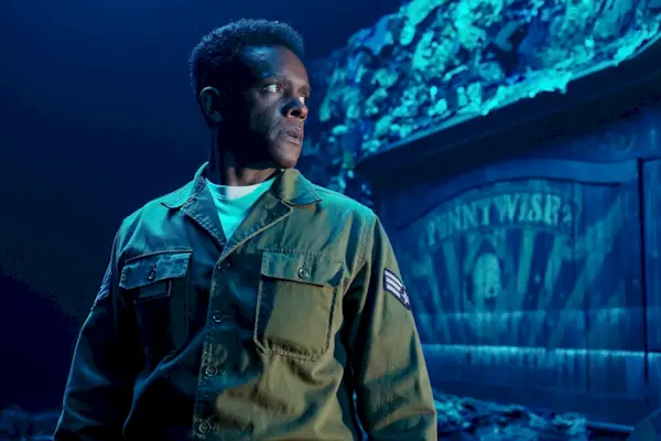 Dick Hallorann (Chris Chalk) parado frente a un carro que dice