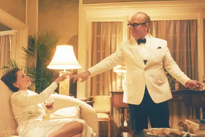 Naomi Watts as Babe Paley, Tom Hollander as Truman Capote in 