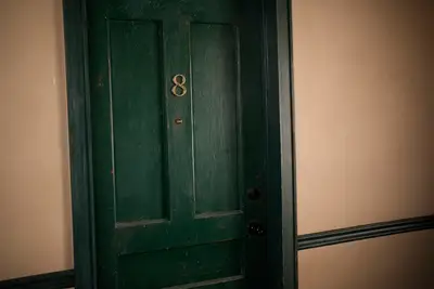A green apartment door with the number 8 on it in 
