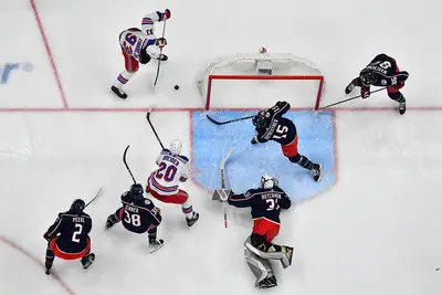 Mika Zibanejad #93 and Chris Kreider #20 of the New York Rangers reach for a loose puck during the first period of a game against the Columbus Blue Jackets