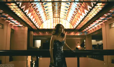 GRISELDA Ep 3 COOL SHOT OF GRISELDA WITH THE LIGHTED CEILING ABOVE HER