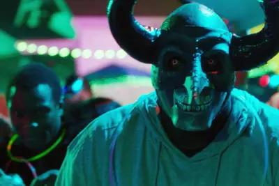 A man gets ready to purge while wearing a horned mask.
