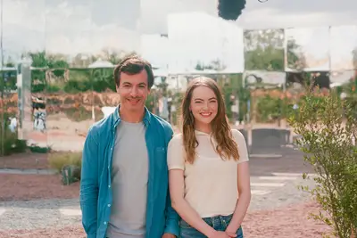 Nathan Fielder and Emma Stone standing in front of a mirrored house in 
